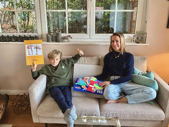 Ein Kind und eine Mutter zeigen ein KIDSartbook und die Zeichnungen des Kindes