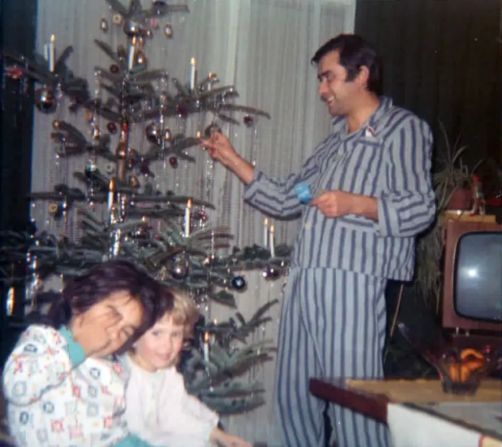 Kindheitserinnerung an einen früheren Weihnachtsabend_Papa-mit-zwei-Kindern-vor-dem geschmückten-Weihnachtsbaum