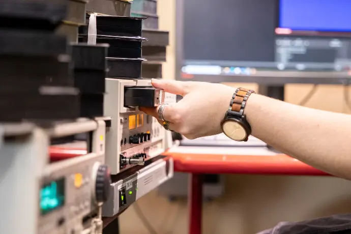 Videotechniker prüft mit einer VHS einen Videorekorder