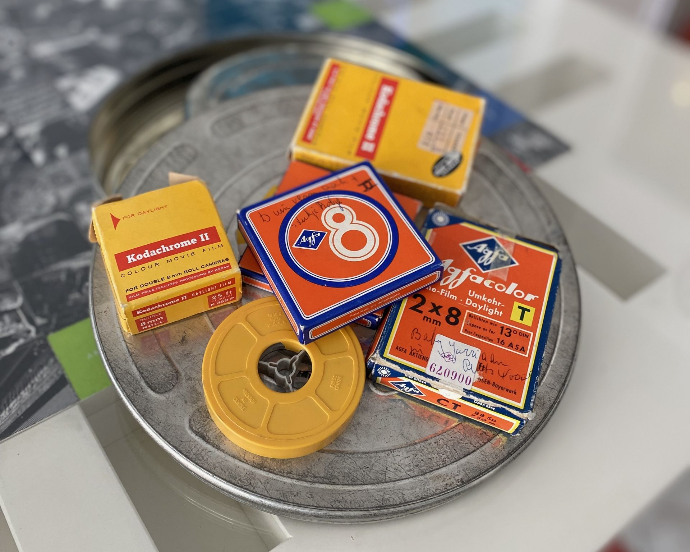 Kleine Super 8 Filme liegen auf einer 16mm Metallfilmrolle