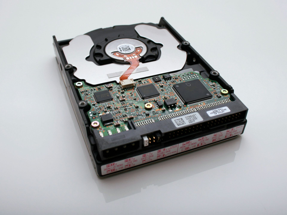 Foto einer geöffneten Computer Festplatte, die defekt ist.