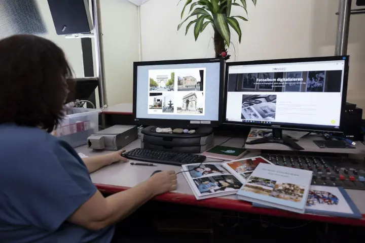Foto - Digitalisierung - Computer Frau beim Digitalisieren analoger Fotos am Computerarbeitsplatz zum richtigen Zeitpunkt