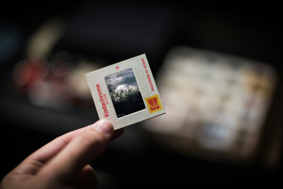 Kleinbilddia wird von Fingern einer Person gehalten