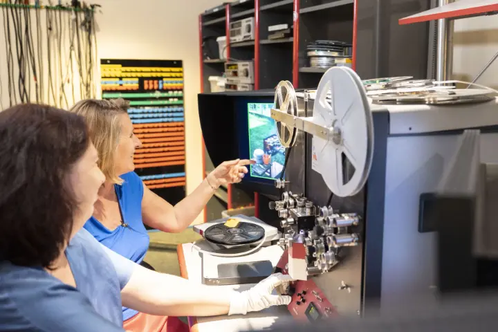 Zwei Mitarbeiterinnen bei der professionellen Digitalisierung von Super 8 Filmen für eine digitale Familienchronik – Erinnerung und Familiengeschichte dauerhaft sichern.
